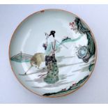 A large Chinese famille verte shallow bowl decorated with a robed lady and a deer, 31cms diameter.