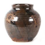 A Chinese brown glazed pottery vase decorated with flowers and fruit, 20cms high.