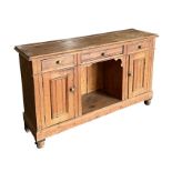 A Victorian pine dresser base with three frieze drawers above a dog kennel flanked by two cupboards,