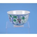 A Chinese Wucai style tea bowl decorated with fruiting foliage, six character mark to the underside,