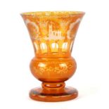 A Bohemian amber flashed glass vase with acid etched decoration depicting a church within a