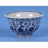 A Chinese blue & white footed bowl decorated with scrolling flowering foliage, 9.5cms diameter.