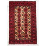 A Persian Hamadan woollen runner with repeated guls on a red ground, 206 by 125cms (10).