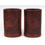 A pair of carved bamboo Bitong brush pots, each depicting figures on Oxon, each 17cms wide (2).