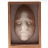 A plaster death mask, 26cms high, in a wooden crate.