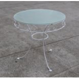 A painted wire work two-tier garden table with a circular frosted glass top, 76cms diameter.