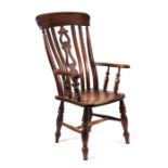 A 19th century elm kitchen armchair with pierced back splat, solid seat and turned front legs joined