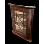 A 19th century mahogany hanging wall display cabinet with astragal glazed panelled door enclosing