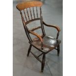 A 19th century elm kitchen armchair with spindle back, scroll arms, solid seat, on ring turned front