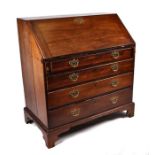 A George III oak bureau, the fall-front enclosing a fitted interior, above four graduated long
