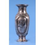 A Japanese silver coloured metal baluster vase with prunus repousse decoration and four panels, each