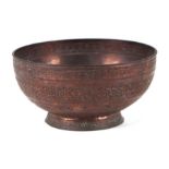 A Persian copper footed bowl decorated with fish and foliate scrolls, 19cms diameter.