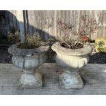 A pair of reconstituted stone planters of classical urn form, each 40cms diameter. (2).