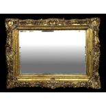 A carved giltwood overmantle mirror in the rococo taste with rectangular bevel edged plate, 120cms