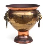 A large copper and brass planter with lion mask ring handles. 41cm high