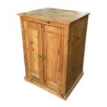 A pine cupboard, the twin panelled doors enclosing a shelved interior, on a plinth base, 67cms
