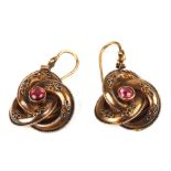A pair of yellow metal Etruscan Revival style knot drop earrings set with a central garnet cabochon,