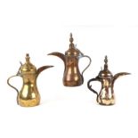 A group of three Turkish / Islamic brass dallah coffee pots, the largest 29cms high (3).