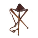 A 19th century Military Campaign folding tripod stool with leather seat with impressed maker's
