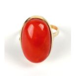 An 18ct gold ring set with a large coral cabochon, approx UK size 'O', 6.7g.