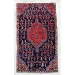 A Persian hand knotted rug with stylised design, on a blue ground, 183 by 110cms (68).