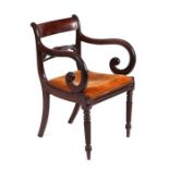 An early 19th century Regency mahogany carver chair with carved head rail, scroll arms and drop-in