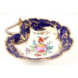 An 18th / 19th century porcelain leaf shaped dish decorated with flowers on a blue ground with