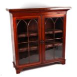 A 19th century walnut display cabinet, the pair of arched glazed doors enclosing a leather trimmed