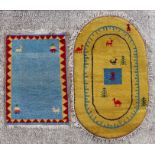 A Persian Gabbeh rug decorated with stylised animals on a yellow ground, 76 by 160cms; together with
