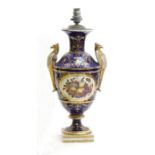 A 19th century English porcelain vase with griffin handles, the decoration depicting fruit on a blue