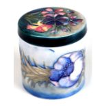 A Moorcroft pot and cover of cylindrical form decorated with poppies and spring flowers, impressed