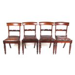 A set of four William IV rosewood dining chairs with carved back rails, drop-in seats and turned and