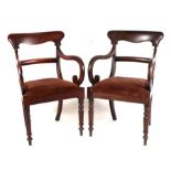 A pair of William IV mahogany carver chairs with scroll arms, drop-in seats and turned and