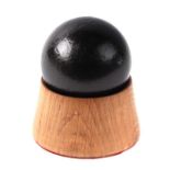 An iron cannon ball. Approximate diameter of 7cms (2.75ins) on a turned oak mount