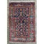 A Northwest Persian Bijar rug with repeating floral motifs on a dark blue ground within a multi