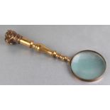 A magnifying glass with cast brass handle and bulldog head terminal, 32cms long.