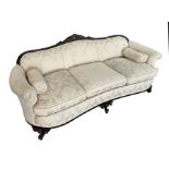 A late Victorian / Edwardian upholstered three-seater sofa with carved show wood and gnarl front