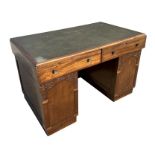 A 1940's / 50's pedestal desk with leatherette inset top above two frieze drawers, on carved