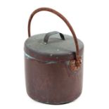 A copper lidded pan with iron hoop handle.