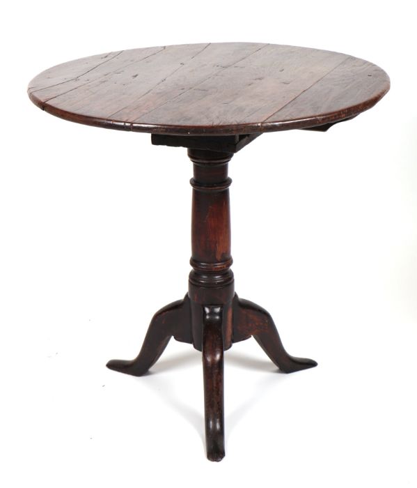 A 19th century oak tilt-top table on turned column and tripod base, 69cms diameter.