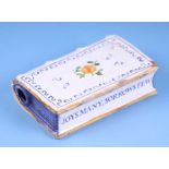 An English Delft tin glaze handwarmer in the form of a book with moulded decoration, painted flowers