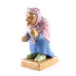 A Danish pottery figure depicting an old crone pointing a finger, incised inscription to base, 13cms