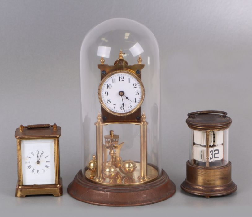 An Anniversary type clock under a glass dome, 30cms high; together with a Waterbury Clock Company