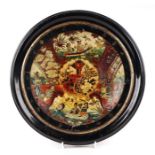 A 19th century chinoiserie pottery plate mounted under glass in an ebonised frame, overall 34cms