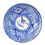 A late 18th century Delft blue & white charger decorated with a bird, with old rivet repairs,