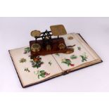 A Victorian scrap album; together with a set of brass and oak postal scales.