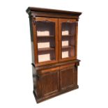 A Victorian bookcase on cupboard, the pair of glazed doors enclosing a shelved interior with