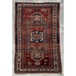 A Persian hand knotted rug decorated with a geometric pattern on a red ground, 124 by 241cms.