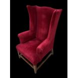 A 19th century upholstered wingback armchair on square tapering legs.