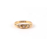 An 18ct gold threes stone diamond gypsy ring, approx UK size 'O', 3.2g.